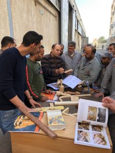 Dr Nour Mohamed Badr shows woodwork examples to staff at Pinocchio.