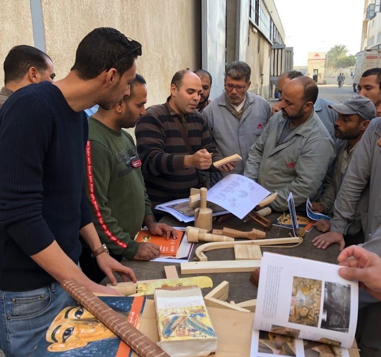 Dr Nour Mohamed Badr shows woodwork examples to staff at Pinocchio.